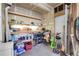 Well organized garage with shelving and workbench featuring tools and storage containers at 5457 S Valdai St, Aurora, CO 80015