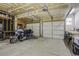 Spacious garage featuring exposed ceilings and ample room for storage with two garage doors and a motorcycle at 5457 S Valdai St, Aurora, CO 80015