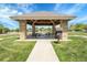 Inviting neighborhood gazebo with stone pillars, picnic tables, and lush green landscaping on a sunny day at 5457 S Valdai St, Aurora, CO 80015