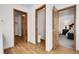 Bright hallway featuring wood floors and doors leading to the bathroom and bedroom at 5457 S Valdai St, Aurora, CO 80015
