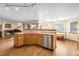 Bright and open kitchen featuring wood flooring, a center island, and views of the living room at 5457 S Valdai St, Aurora, CO 80015