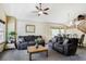 Spacious living room with cozy sofas, a ceiling fan, and large windows providing natural light at 5457 S Valdai St, Aurora, CO 80015