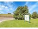Community park sign, lush green lawn and trees and views of a building on a hill in the distance at 5457 S Valdai St, Aurora, CO 80015