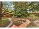 Landscaped backyard featuring a wooden pathway and lush plants at 7770 S Ivy Way, Centennial, CO 80112