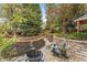 Serene backyard featuring a stone patio, wooden pathway, and lush greenery at 7770 S Ivy Way, Centennial, CO 80112
