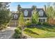 Charming brick home with manicured lawn, mature trees, and an attached two-car garage at 7770 S Ivy Way, Centennial, CO 80112