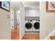Convenient laundry room with front-load washer and dryer, white cabinets and patterned tile floor at 7770 S Ivy Way, Centennial, CO 80112