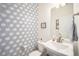 Chic powder room with geometric wallpaper, modern sink, and stylish decor at 10207 Xanadu St, Commerce City, CO 80022