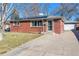 Brick ranch home with solar panels, attached garage, and landscaped yard at 2594 S Tennyson Way, Denver, CO 80219