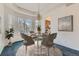 Staged dining area with a round table, chandelier, and view to kitchen area at 10340 Winona Ct, Westminster, CO 80031