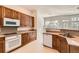 Functional kitchen with wood cabinets, stainless steel appliances, granite countertops, and a connecting dining area at 10340 Winona Ct, Westminster, CO 80031