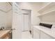 Functional laundry room with a sink, white washer and dryer, and open shelving at 10340 Winona Ct, Westminster, CO 80031