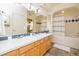 Bathroom with a double sink vanity, large mirror, decorative lighting, and a shower/tub combination at 1747 N Washington St # C303, Denver, CO 80203