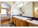 Bathroom with a double sink vanity, large mirror, decorative lighting, and a doorway to another room at 1747 N Washington St # C303, Denver, CO 80203