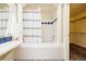 Bathroom featuring a tub/shower with decorative tile and column accents, along with a large walk-in closet at 1747 N Washington St # C303, Denver, CO 80203