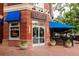 Restaurant exterior with blue awning, brick facade, and outdoor patio seating at 1747 N Washington St # C303, Denver, CO 80203