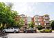 Multi-story brick building with balconies, and parked cars visible in front at 1747 N Washington St # C303, Denver, CO 80203