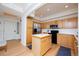 Bright kitchen with a center island, oak cabinets, stainless steel appliances, and hardwood floors at 1747 N Washington St # C303, Denver, CO 80203