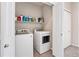 Bright laundry room with a white washer, dryer, and storage shelf at 15550 W 64Th Pl # D, Arvada, CO 80007