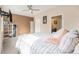 Main bedroom with a large bed, mounted TV, fan, and access to an ensuite bath at 15550 W 64Th Pl # D, Arvada, CO 80007