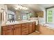 Bright bathroom features double sinks, granite counters, tub, and ample natural light at 4545 S Monaco St # 114, Denver, CO 80237