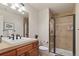 Well-lit bathroom featuring glass shower, toilet, sink vanity, and neutral tile work at 4545 S Monaco St # 114, Denver, CO 80237