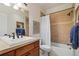 Bathroom featuring tub/shower combo, wooden cabinets, and neutral color palette at 4545 S Monaco St # 114, Denver, CO 80237