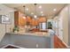 An open kitchen shows granite counters, wood cabinets, and a stainless fridge at 4545 S Monaco St # 114, Denver, CO 80237