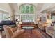 Elegant living room featuring high ceilings, piano, plantation shutters, and hardwood floors at 4545 S Monaco St # 114, Denver, CO 80237