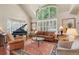 Elegant living room with high ceilings, grand piano, hardwood floors, and abundant natural light at 4545 S Monaco St # 114, Denver, CO 80237