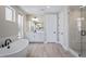 Bright bathroom featuring a soaking tub, double vanity, and glass enclosed shower with attractive tiling at 6955 Sunstrand Ct, Castle Pines, CO 80108