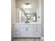 Bathroom vanity with white cabinets, drawers, marble countertop, black fixtures and large mirror at 6955 Sunstrand Ct, Castle Pines, CO 80108