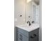 Contemporary bathroom vanity with grey cabinet, marble countertop, mirror and black hardware at 6955 Sunstrand Ct, Castle Pines, CO 80108