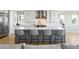 Modern kitchen with stainless steel appliances, center island with bar seating, and white cabinetry at 6955 Sunstrand Ct, Castle Pines, CO 80108