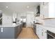 Bright kitchen featuring a large island, stainless steel appliances, custom cabinetry, and modern fixtures at 6955 Sunstrand Ct, Castle Pines, CO 80108