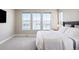 Bright main bedroom with plush carpets, a large bed, and oversized windows at 6955 Sunstrand Ct, Castle Pines, CO 80108