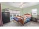 A green bedroom has carpeted floors, a ceiling fan, a large window and a wooden bed frame at 8400 Adams Way, Denver, CO 80229