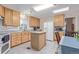 Well-lit kitchen featuring light wood cabinets, center island, and modern appliances including a refrigerator and built-in microwave at 8400 Adams Way, Denver, CO 80229