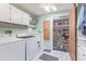 Laundry room with newer machines, white cabinets, and an adjoining pantry, offering functionality and storage at 8400 Adams Way, Denver, CO 80229