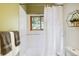 Bright bathroom with white tiles, a window view, and a decorative shower curtain at 11760 Baca Rd, Conifer, CO 80433