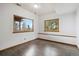 Cozy bedroom with two large windows offering scenic views and dark wood floors at 11760 Baca Rd, Conifer, CO 80433