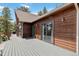 This spacious deck offers sliding glass doors, exterior lighting, and beautiful wood siding at 11760 Baca Rd, Conifer, CO 80433