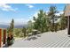 Enjoy mountain views from this outdoor deck space with table, chairs, and potted plants at 11760 Baca Rd, Conifer, CO 80433