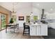 Bright kitchen and dining room with pendant lighting, stainless steel appliances, and hardwood floors at 11760 Baca Rd, Conifer, CO 80433