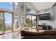 Bright living room with floor to ceiling windows, two chairs, and a leather sofa at 11760 Baca Rd, Conifer, CO 80433