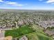 Scenic aerial perspective showcasing a neighborhood, green fields, and the city skyline in the distance at 5554 S Ward Way, Littleton, CO 80127