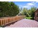Enjoy outdoor living on this spacious back deck with wood railing and mature trees at 5554 S Ward Way, Littleton, CO 80127