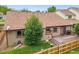 View of the backyard featuring a well-maintained lawn, wooden fence, and a cozy deck area at 5554 S Ward Way, Littleton, CO 80127