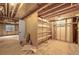 Unfinished basement with an exposed ceiling and ductwork offers a canvas for customization with shelving at 5554 S Ward Way, Littleton, CO 80127