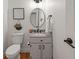 Charming powder room featuring a round mirror, modern fixtures, and decorative accents at 5554 S Ward Way, Littleton, CO 80127